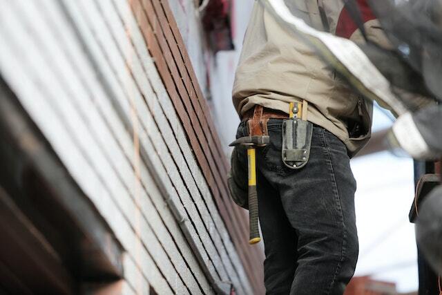 a contractor wearing a tool belt with a hammer on it